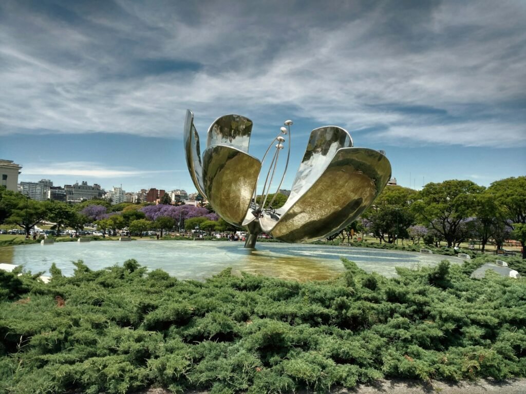 vista do Floralis Generica, na Recoleta, Buenos Aires, um monumento que é um flor metálica de pétalas abertas em cima de um espelho d