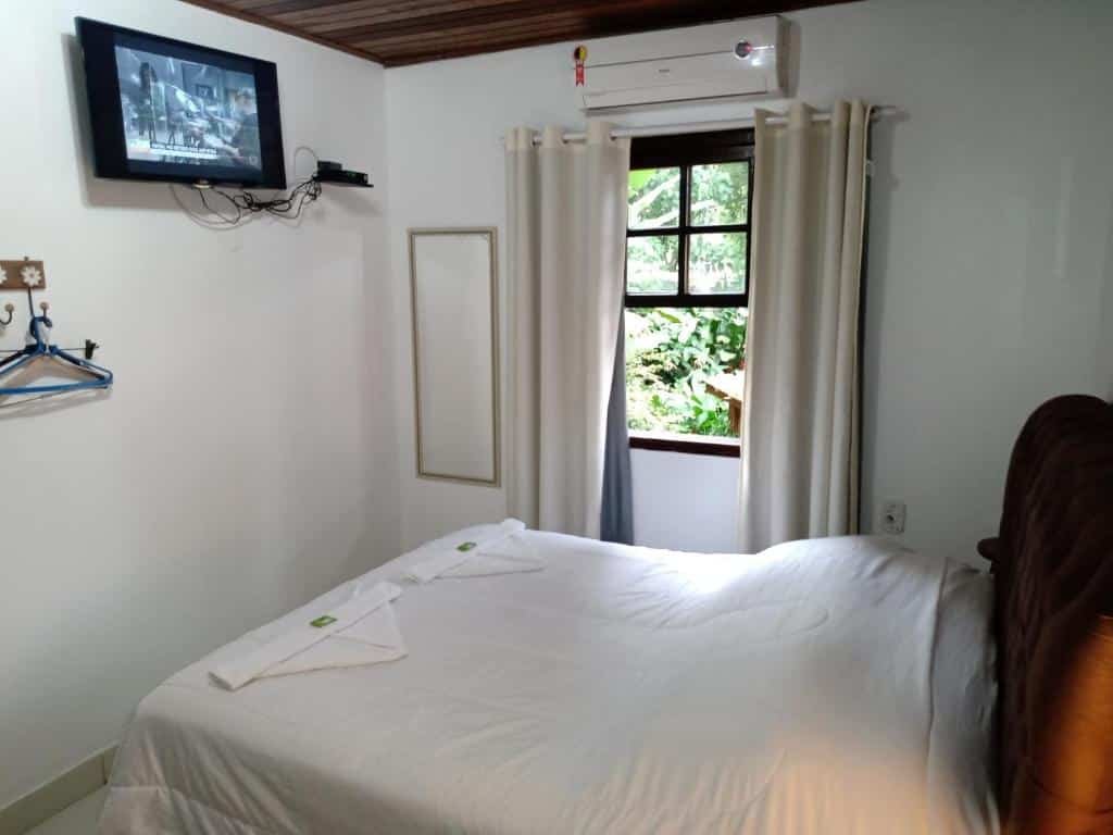 Quarto de casal com TV e espelho na Pousada Bawa, uma das pousadas em Ubatuba