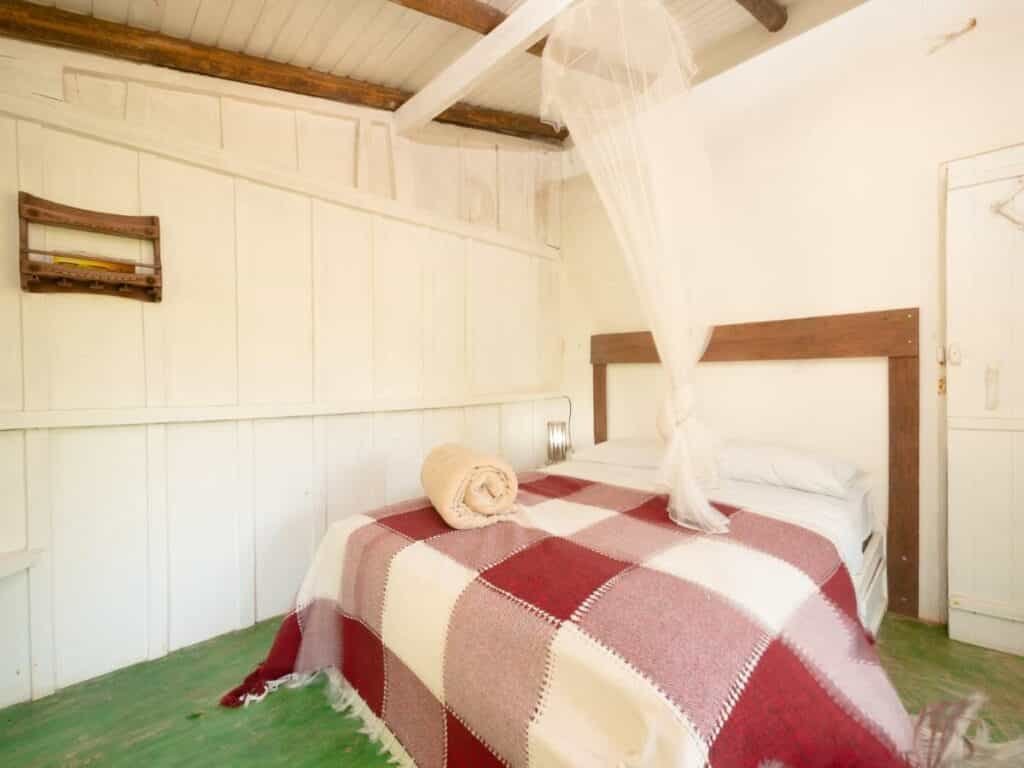 Quarto com cama e mosqueteira na Pousada Canto Bravo, na Praia do Bonete