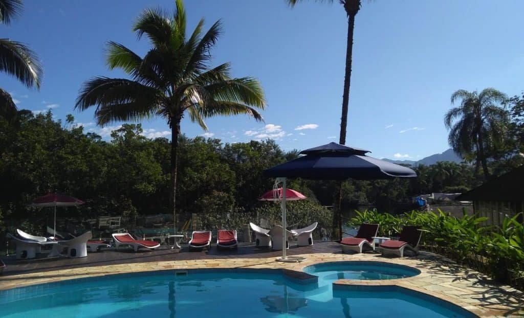 Piscina da Pousada Una com vegetação em volta