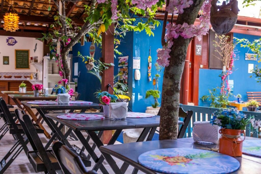 área comum com mesinhas coloridas na Pousada Villa Blu Maresias