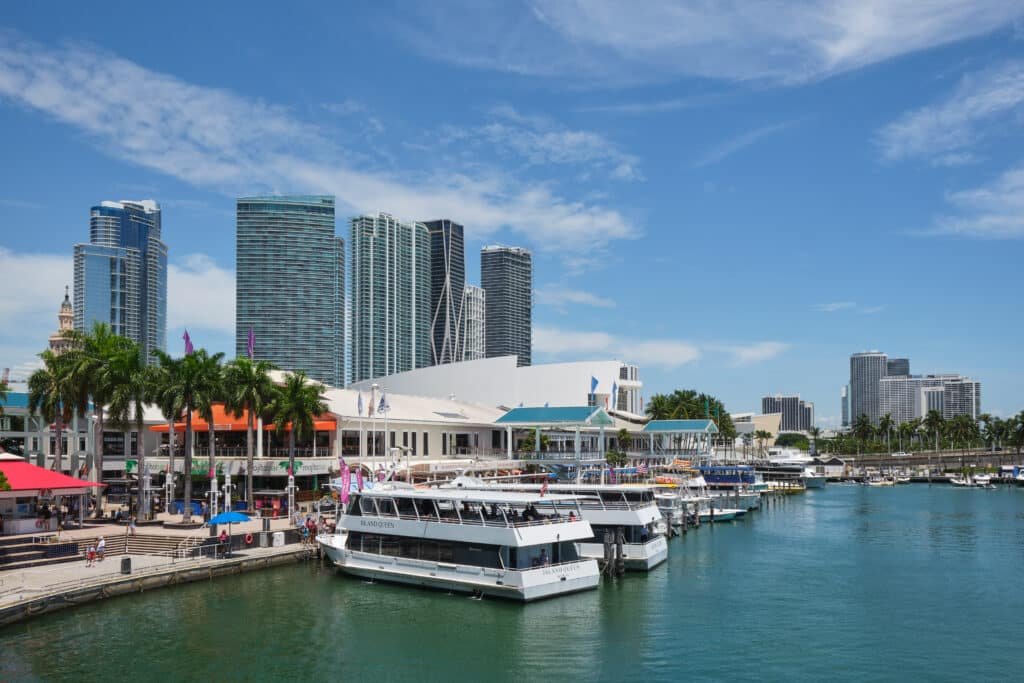 Uma parte da baía em Bayside Marketplace. A água e os barcos estão do lado direito. Em frente a eles, do lado esquerdo, está a parte onde ficam as lojas e estabelecimentos.