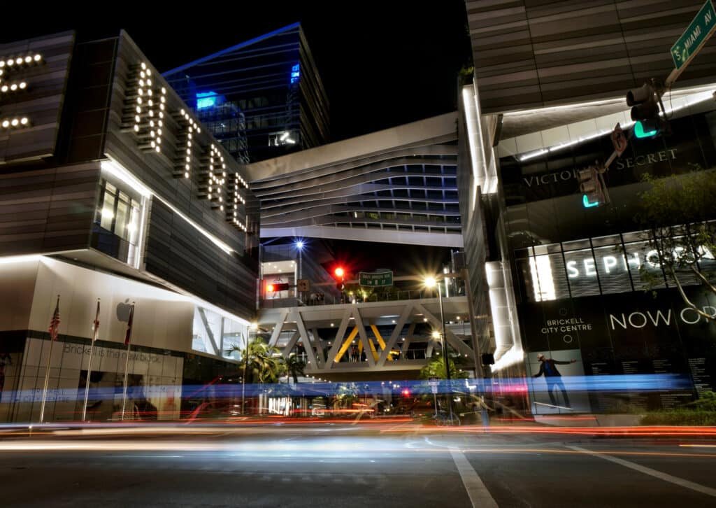 Uma parte do Brickell City Centre durante à noite. É possível ver algumas faixadas e lojas, como Victorias Secret e Sephora. O ambiente está bem iluminado.