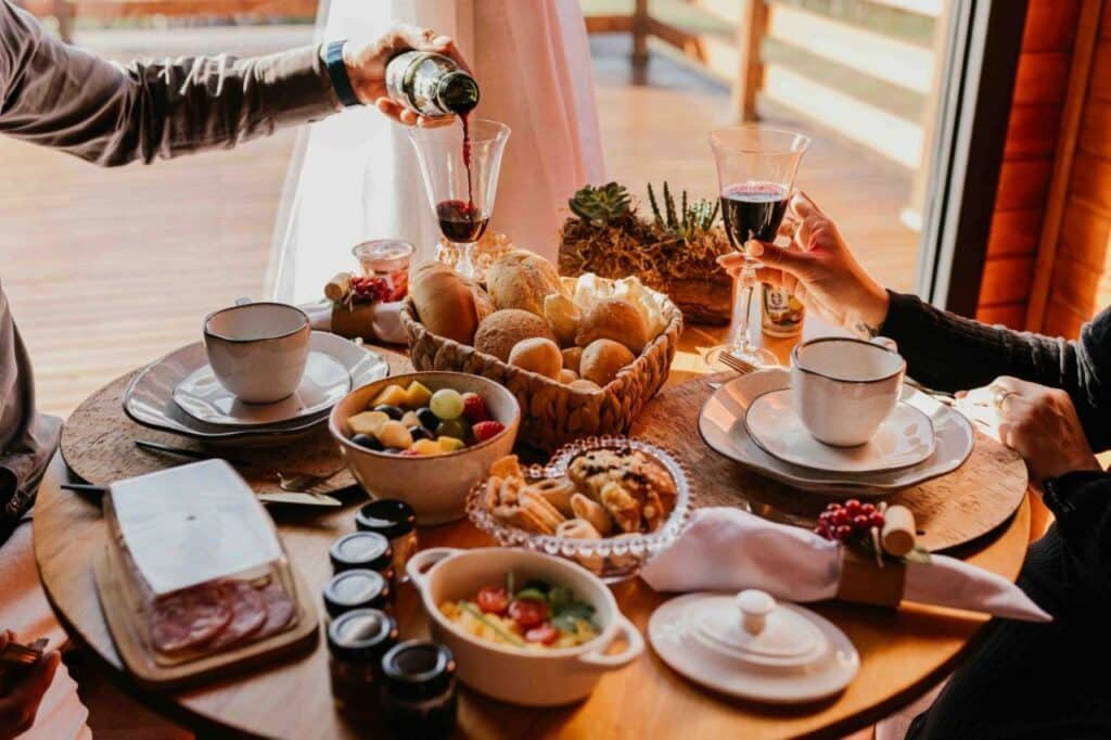 Café da manhã super caprichado na Capanna del Vale, com pães diversos, doces, frios, frutas, suco de uva e vários potinhos de geleia
