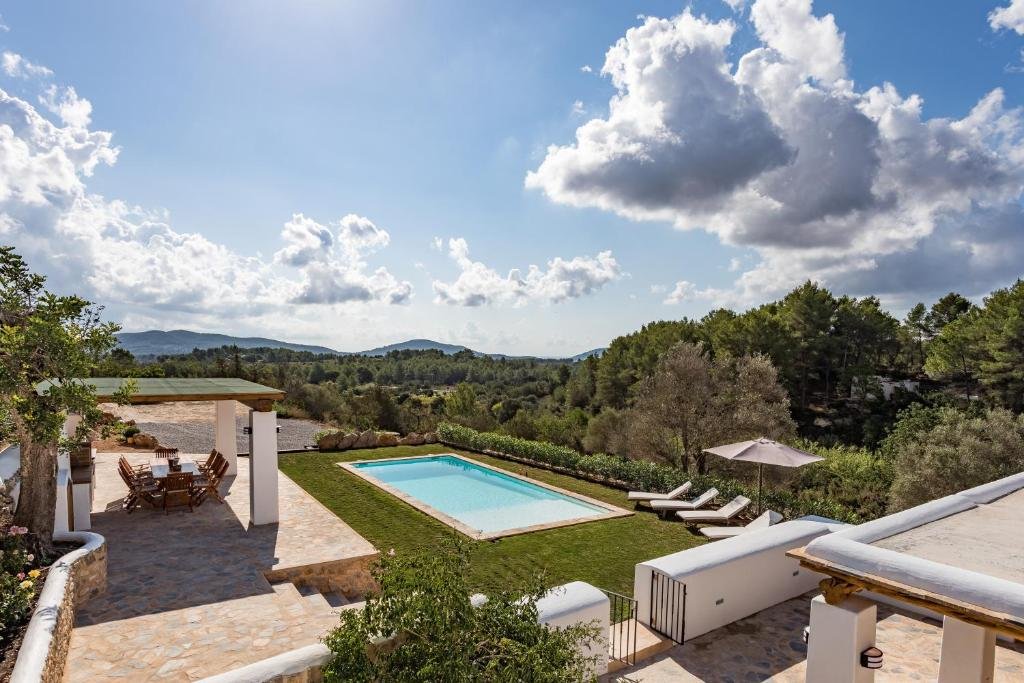 Piscina, espreguiçadeiras, cadeiras e natureza em volta da Can Vinyeta