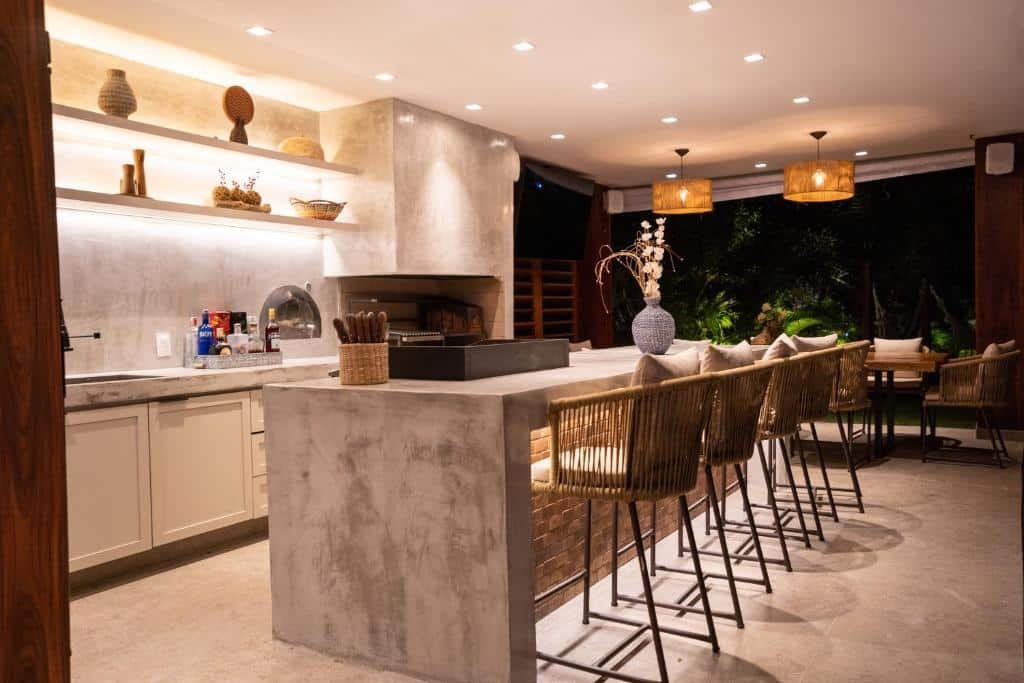 Cozinha da Quintas de Sauipe D10, Casa de 6 suítes com luxo e conforto com balcão a frente com várias banquetas e atrás do balcão armário e pia. Representa airbnb na Costa do Sauípe