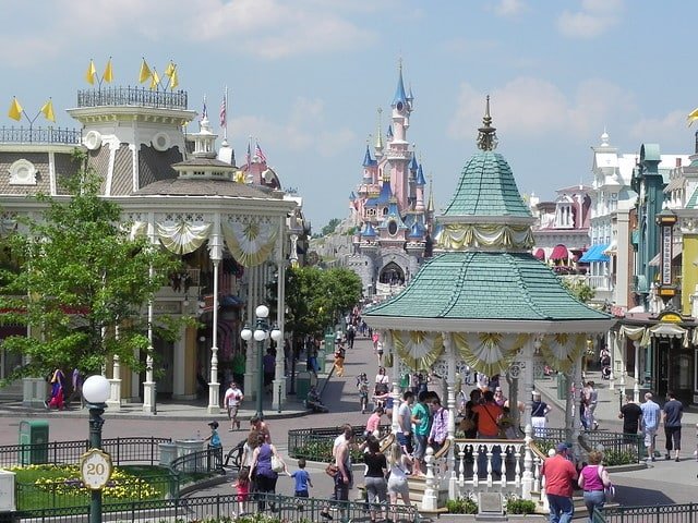 Na foto ve-se a entrada da Disneyland Paris com o castelo da bela adormecida ao fundo e pedestres - Foto: Betty Yobaccio