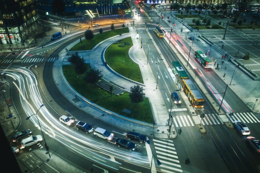 Vista aérea das ruas de Milão com ônibus passando, carros e bondes