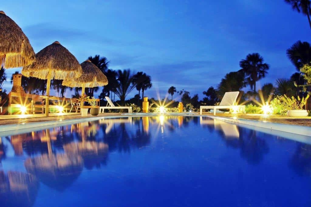 Piscina com luzes ao lado iluminando uma noite da Encantes do Nordeste, uma das pousadas em Barreirinhas