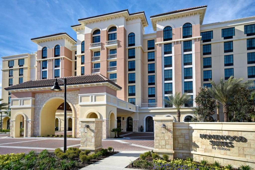 fachada do Homewood Suites By Hilton Orlando Flamingo Crossings, Fl, uma das opções de onde ficar em Orlando, com a arquitetura bem clássica em tons de bege e branco e linhas retas com muitas janelas 