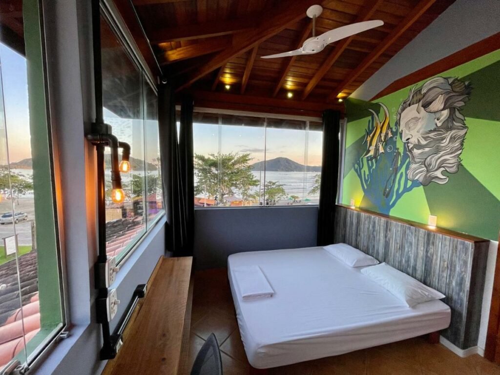 Cama de casal em quarto com vista para o mar em Ubatuba