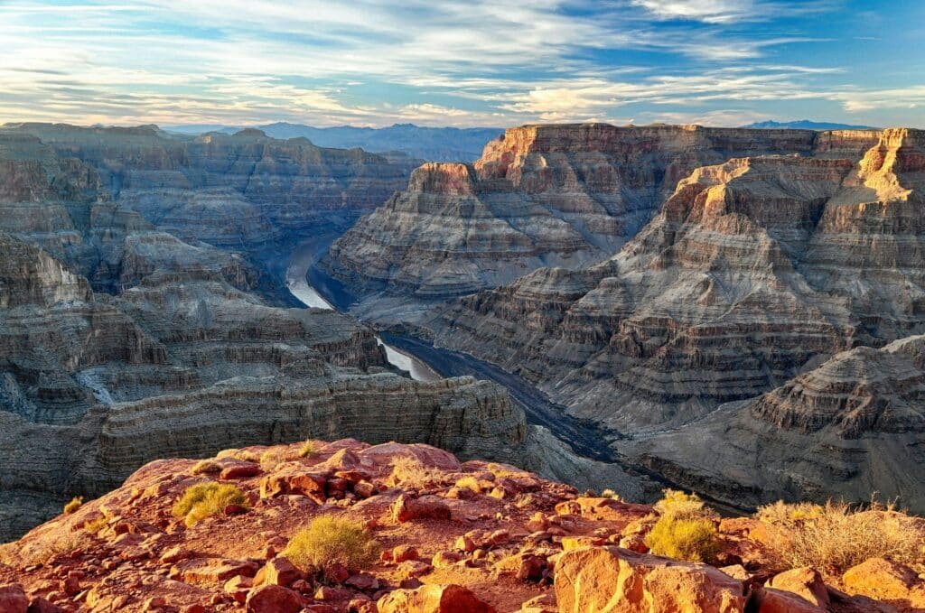 Vista do Grand Canyon de uma parte alta. A foto foi tirada durante o dia, então é possível ver todos os detalhes, o rio que corta o meio e o horizonte. Esse passeio é uma ótima dica de pontos turísticos em Las Vegas.