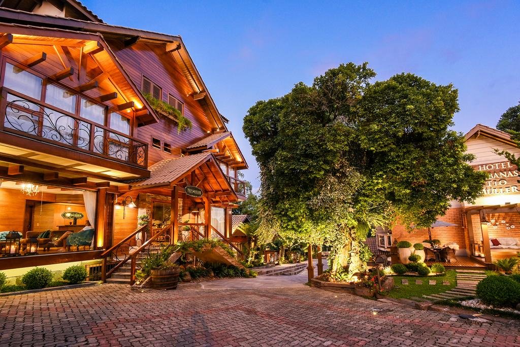 Entrada do Hotel Cabanas Tio Müller, com árvores e luzes