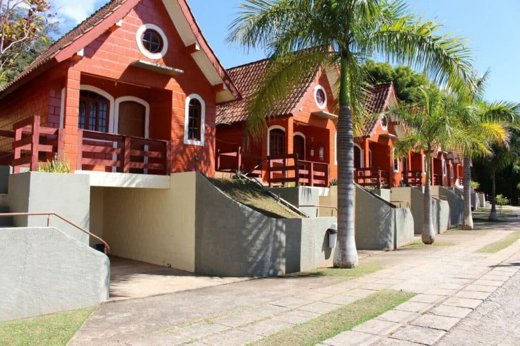 Os chalés vermelhos lado a lado que formam o Hotel Fazenda Estância São Domingos