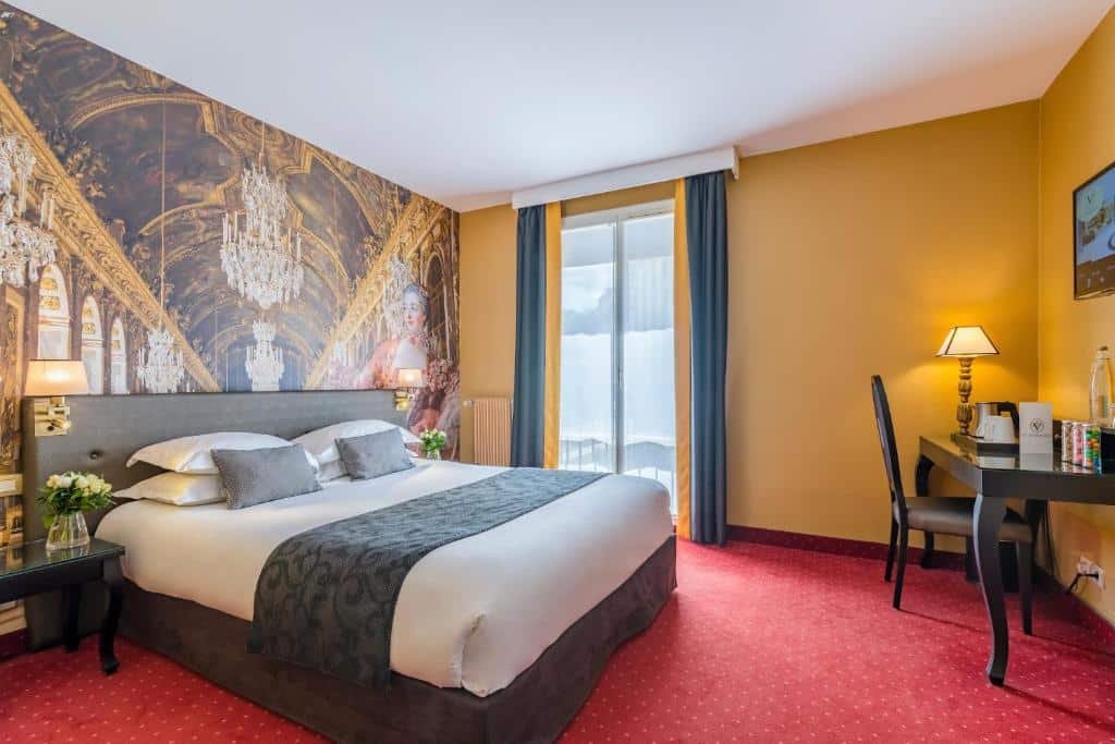 Quarto do Hôtel Le Versailles, um dos hotéis perto do Palácio de Versalhes. Uma cama de casal está encostada na parede ao lado esquerdo com mesinhas de cabeceira, vasos de flores e abajures dos dois lados. A parede atrás tem um mural da Sala dos Espelhos do palácio. Em frente à cama há uma mesa de trabalho com cadeira, abajur e comodidades para chá e café. Na parede acima está uma TV. Ao lado direito da parede lateral à cama fica uma janela alta com cortinas.