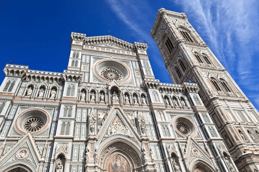 Vista da fachada super detalhada e imponente da Catedral de Santa María del Fiore, em Florença, com esculturas, vitrais e muitos desenhos