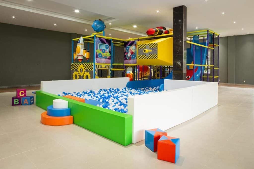 Área de recreação interna do Itatiaia Resort & Eventos, um dos hotéis fazenda no Rio de Janeiro, com piscina de bolinhas, estrutura de escalada colorida e vários formatos para as crianças brincarem.