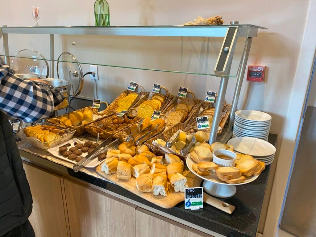 Café da manhã no Laghetto Viverone Estação, com variedade de pães que que incluem pães de forma, baguete, torradinha e até pães de mel