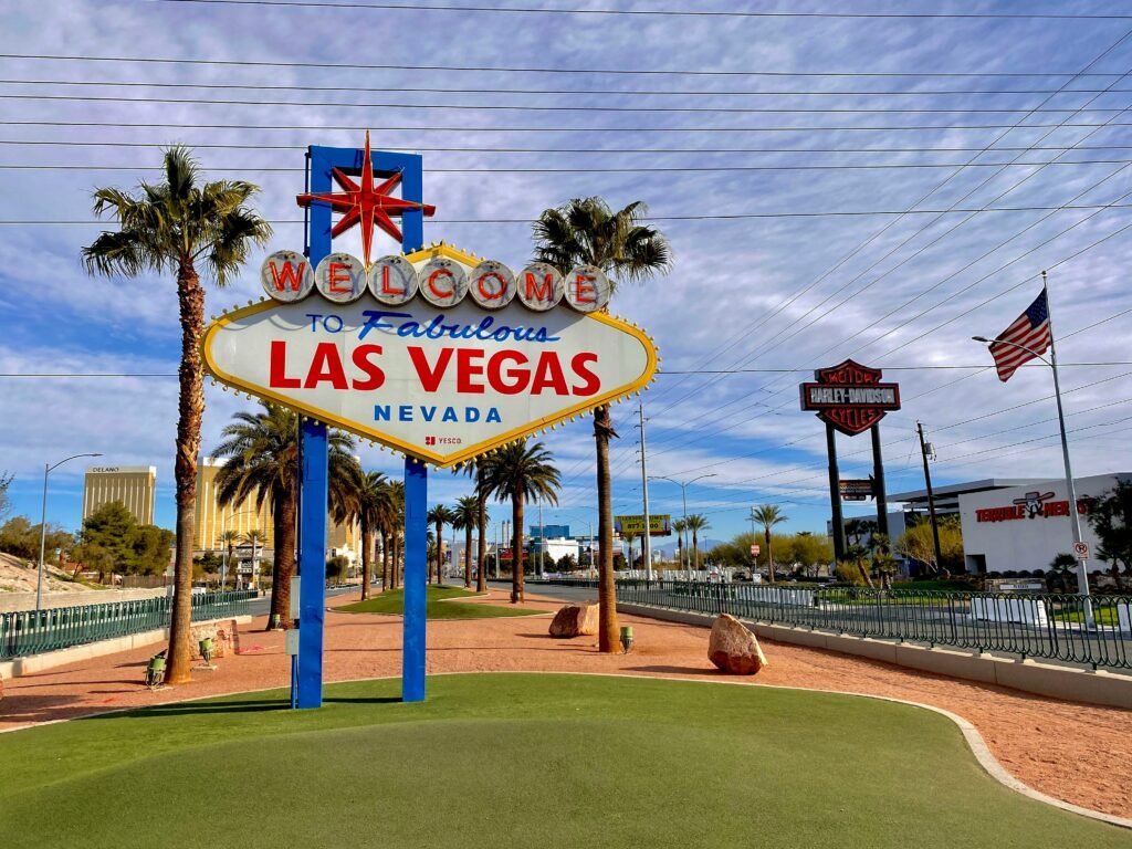 A imagem mostra a placa do começo de Las Vegas, escrito "Welcome to fabulous Las Vegas". Ao fundo é possível já ver alguns hotéis. Imagem para o post de pontos turísticos em Las Vegas.