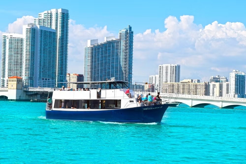 Barco em Biscayne Bay.A água é bem azul e ao fundo estão vários prédios. A foto ilustra a lista de o que fazer em Miami.