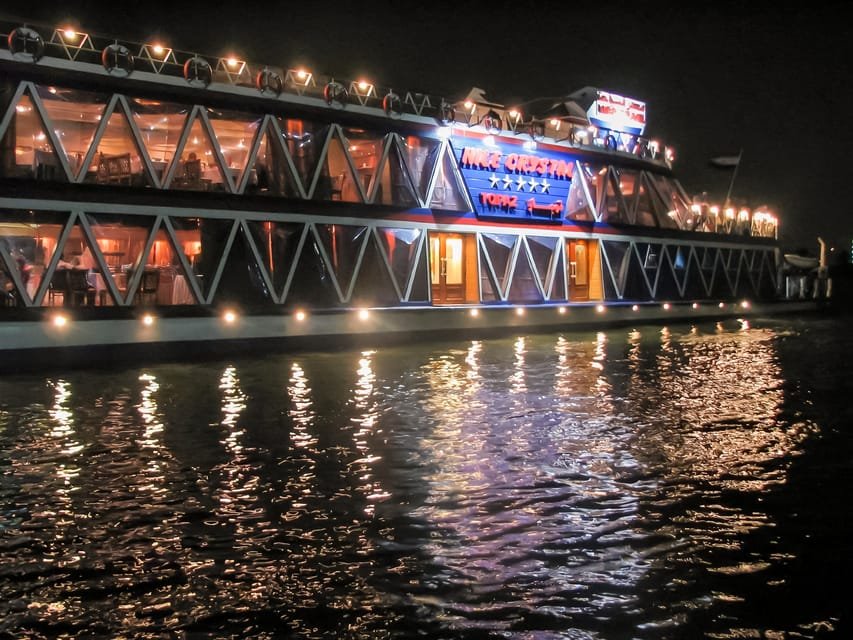 Um barco fluvial bem iluminado à noite no rio NIlo, com grandes janelas e armações triangulares. Imagem para ilustrar post sobre o que fazer no Cairo.