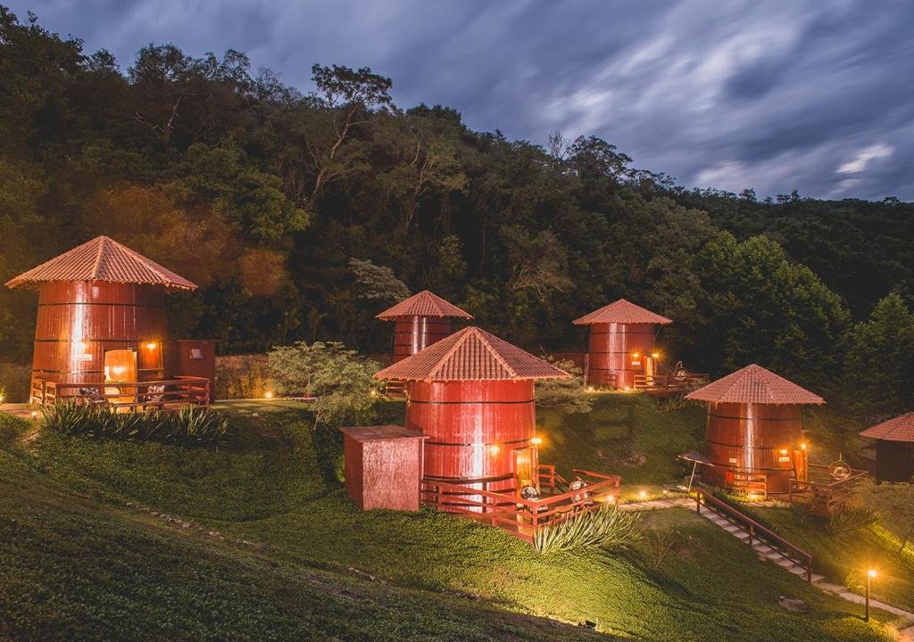 Estruturas de pipas de vinhos, de madeira e de tamanho gigante, espalhadas pelo gramado do Pipas do Vale, uma das alternativas aos hotéis em Bento Gonçalves