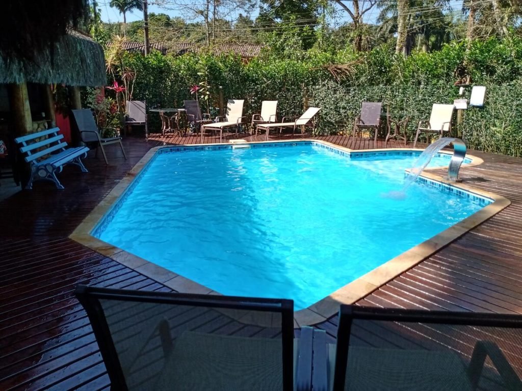 Piscina em formato orgânico ao ar livre em área externa da Pousada Bawa
