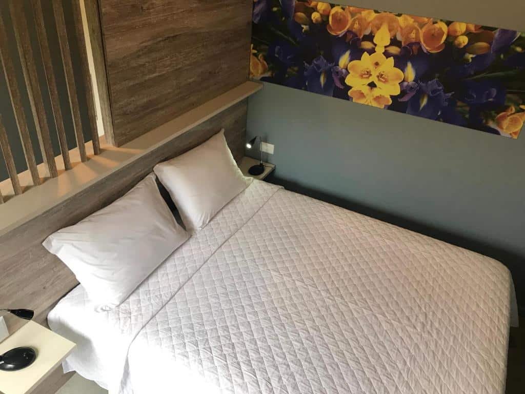 Quarto com cama de casal e cobre leito matelassê na Pousada Castello Montemare