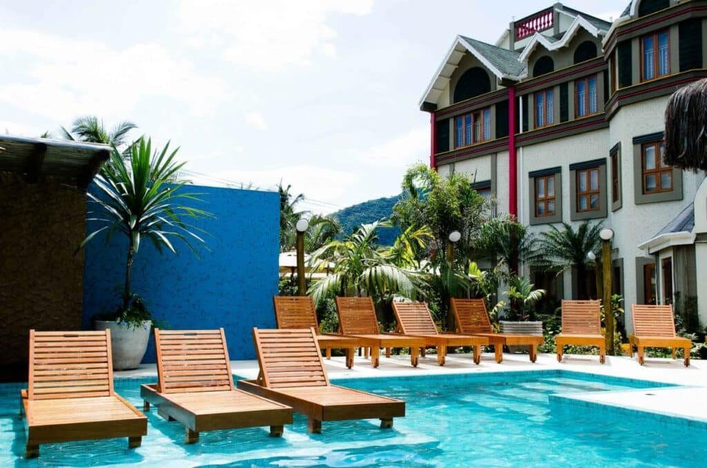 Piscina da Pousada Castello Montemare, uma das pousadas em Ubatuba, com espreguiçadeiras em volta