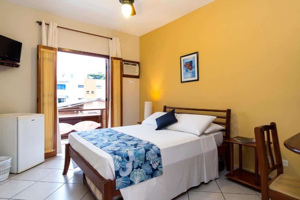 Quarto com TV, frigobar e cama de casal na Pousada Mar Azul