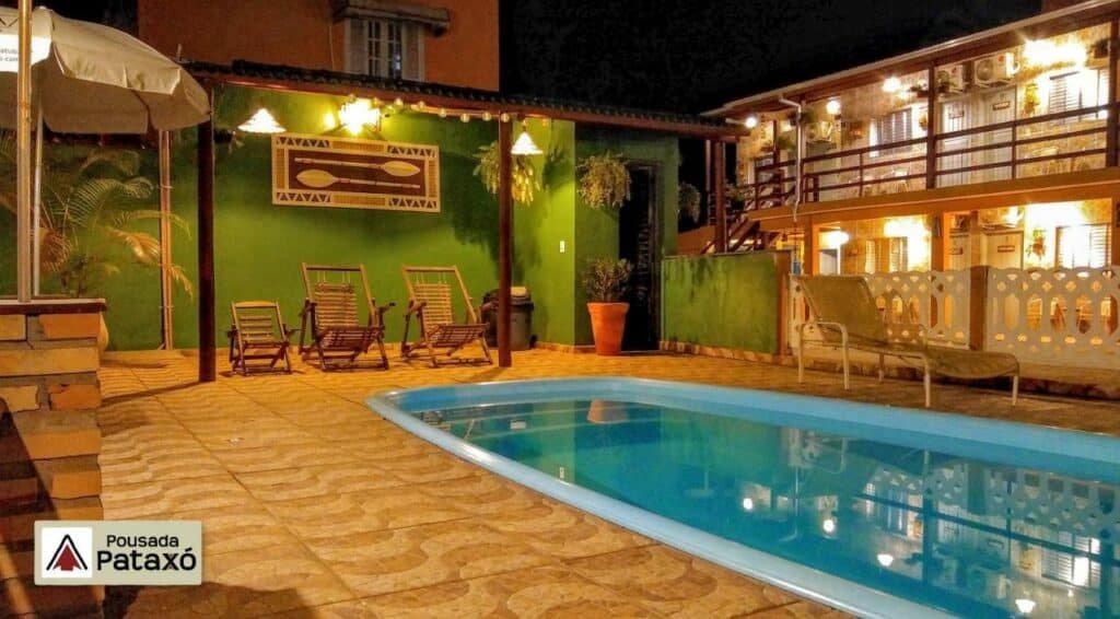 Piscina da Pousada Pataxó com um deck pequeno ao redor com cadeiras e espreguiçadeiras