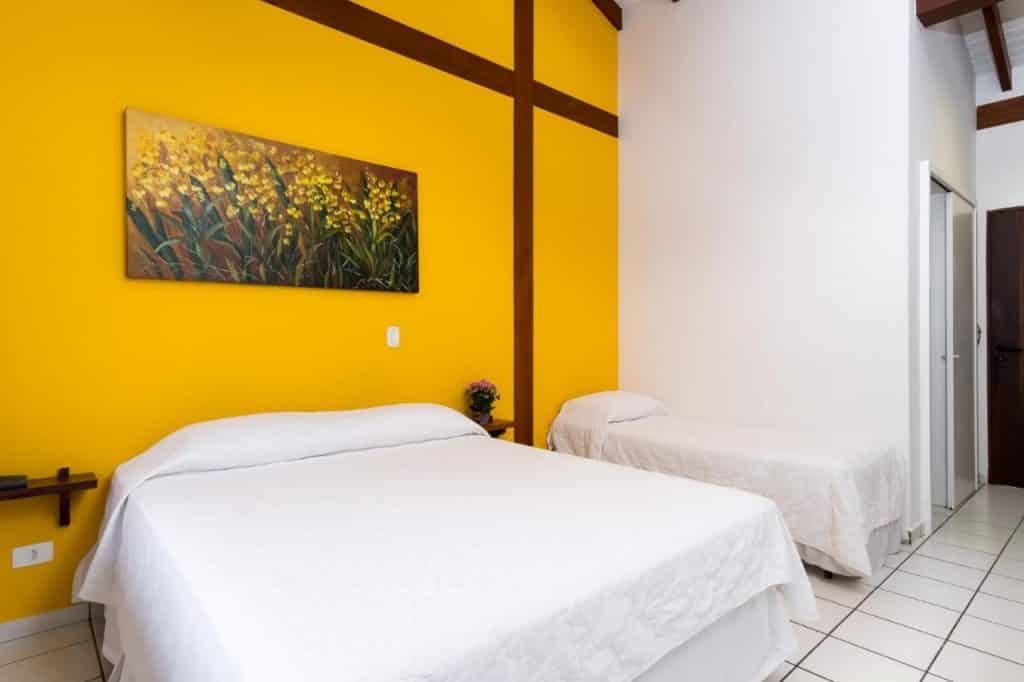 Quarto com cama de casal e cama de solteiro na Pousada Peixes do Mar