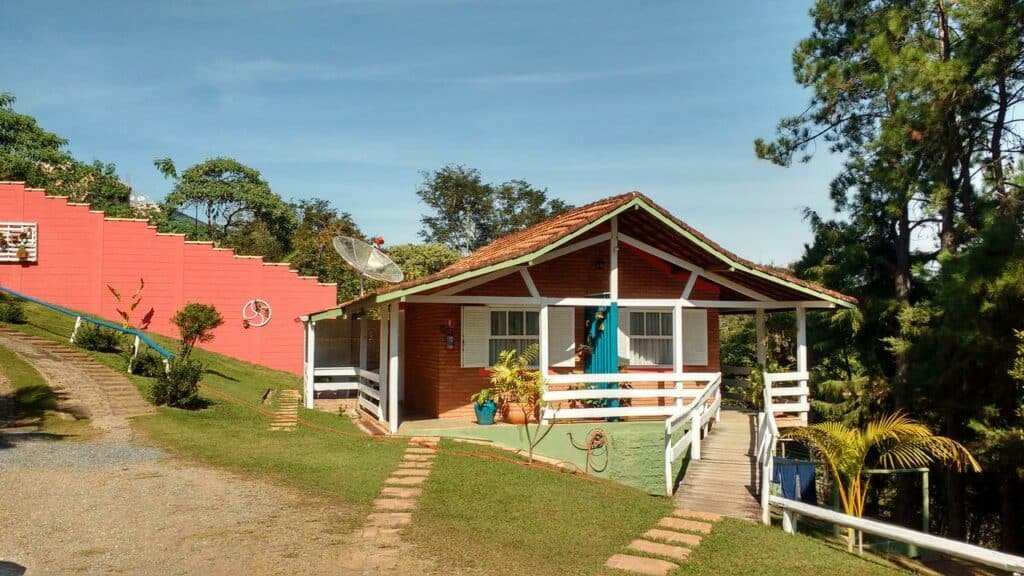 Entrada de um dos chalés e jardins da Pousada Recanto das Girafas, em Cunha