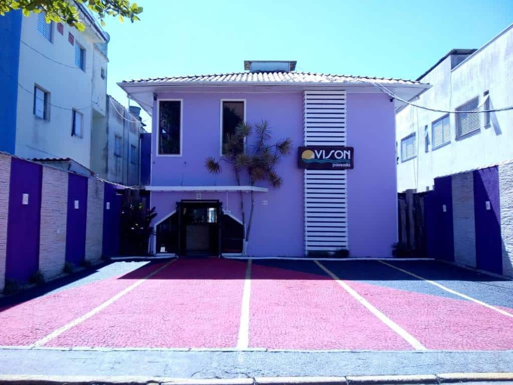 Propriedade da Pousada Vison pintada em tom de lilás e com quatro vagas na frente para estacionar