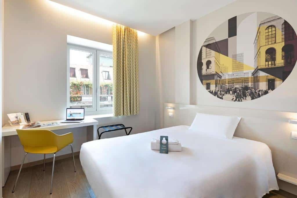 Quarto do B&B Hotel Milano Central Station com uma janela com cortinas, uma mesa de escritório com uma cadeira, e uma cama de casal