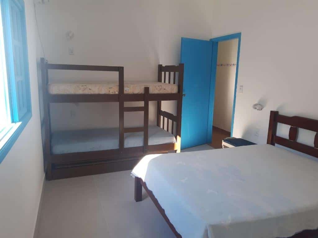 Quarto do Pé na Areia – Casa para temporada com cama de casal do lado direito da imagem e do lado esquerdo uma cama beliche. Representa airbnb na praia de Guaecá.