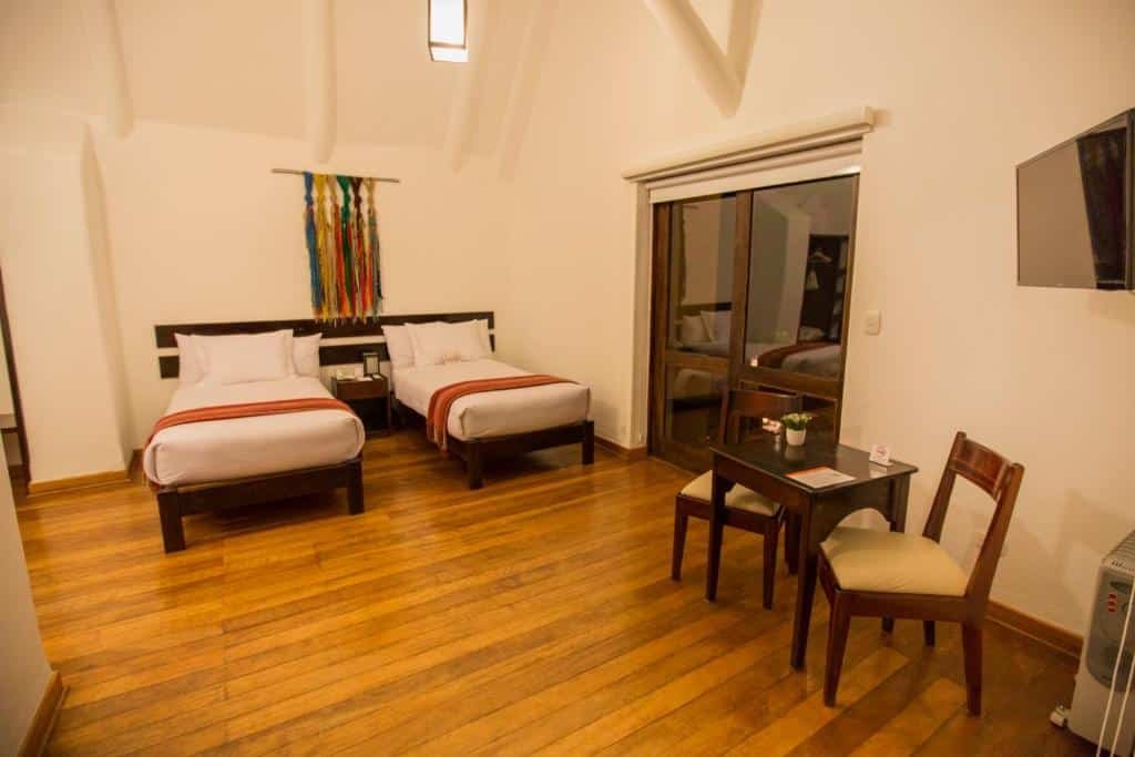 quarto amplo do Tierra Viva Valle Sagrado Hotel no Vale Sagrado dos Incas com duas camas de solteiro, ao lado de uma porta dupla de vidro com acesso a varanda.