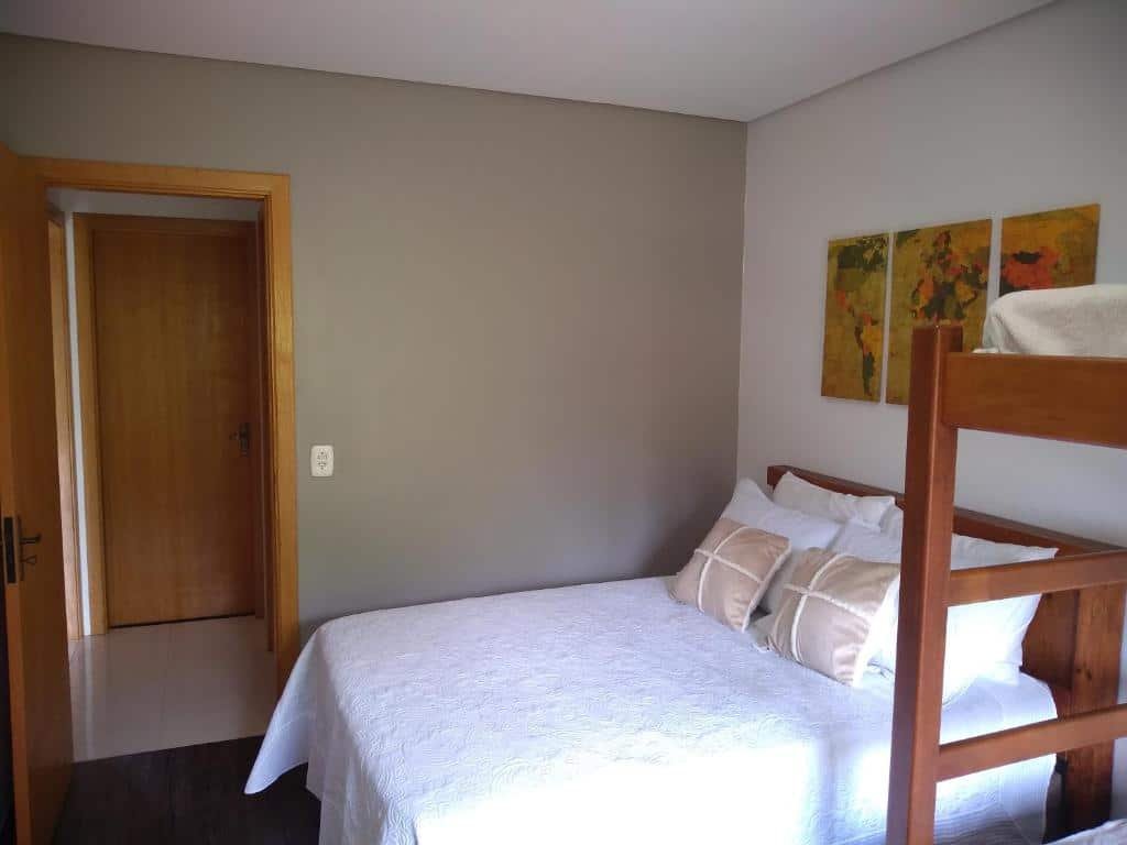 Quarto no Residencial Franzen. Há uma beliche no cantor inferior direito e uma cama de casal ao seu lado. A porta do quarto está à esquerda. Representa o post sobre airbnb em Canela.