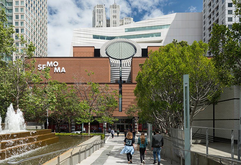 Entrada do Museu de Arte Moderna de San Francisco. Ele possui uma arquitetura moderna e uma fonte logo em frente a entrada.
