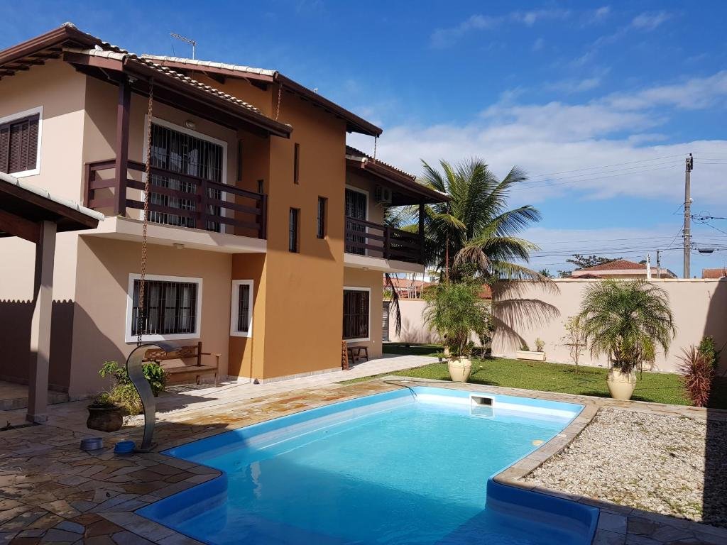 Piscina, com jardim ao lado, da Shangri-La, uma casa de temporada em Itanhaém