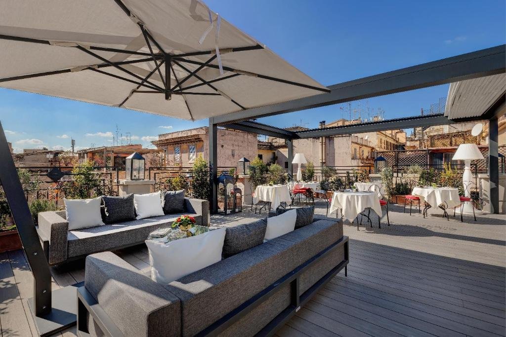 terraço com vista no Dharma Boutique Hotel & SPA com sofás cinza e mesas com cadeiras onde é servido café da manhã