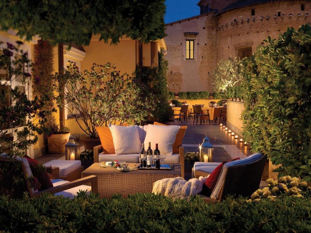 terraço do Hotel Capo dAfrica - Colosseo com várias plantas, mesinha de centro e sofá com várias almofadas