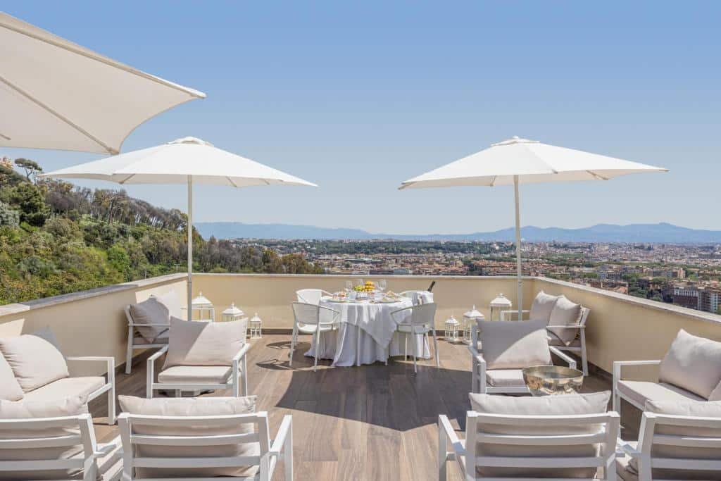 terraço com vista da cidade no Monastero dei Santi com poltronas brancas, mesinhas e cadeiras também brancas