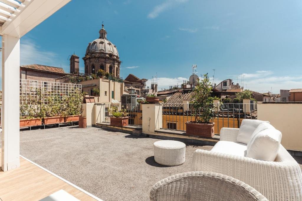terraço do Nikis Collection Navona em um ambiente amplo com sofá branco e cista de monumentos históricos
