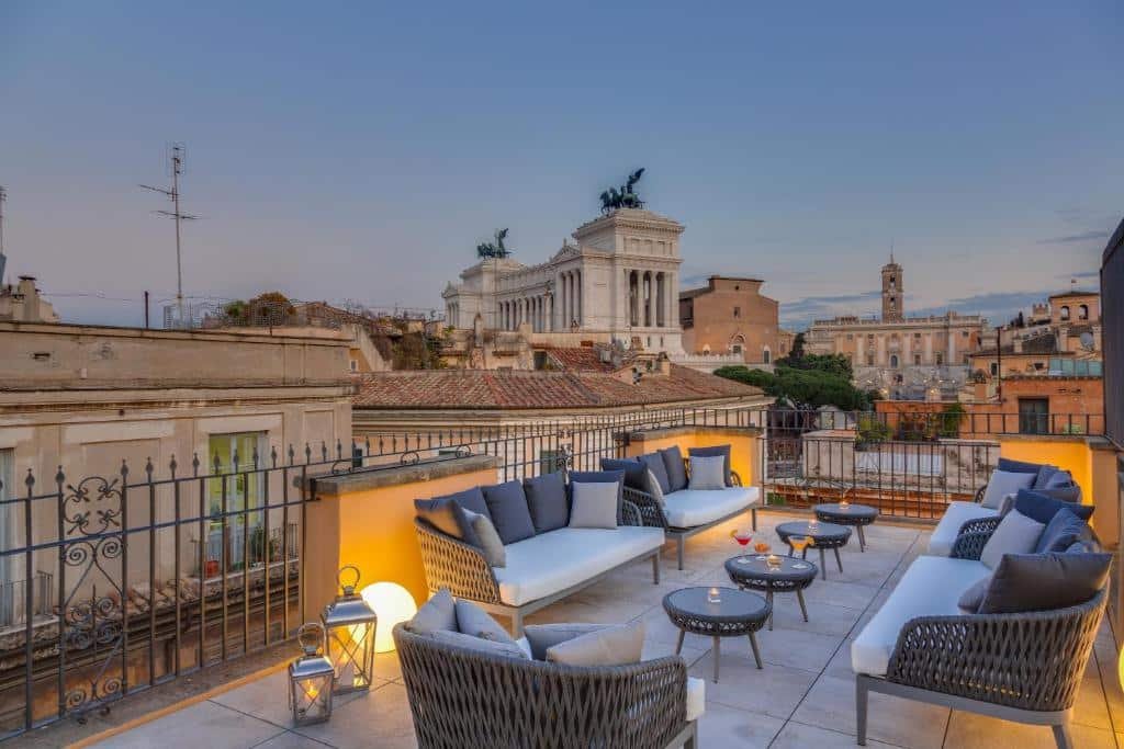 terraço do Otivm Hotel com mesinhas redondas no meio e sofás e poltronas estofadas brancas ao redor com vista do Fórum Romano