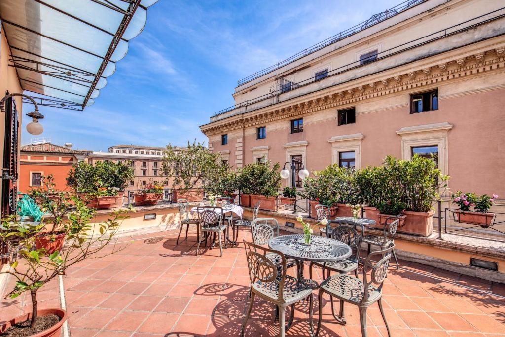 terraço do Parlamento Boutique Hotel com mesas e cadeiras em um ambiente amplo com vista dos prédios e da cidade