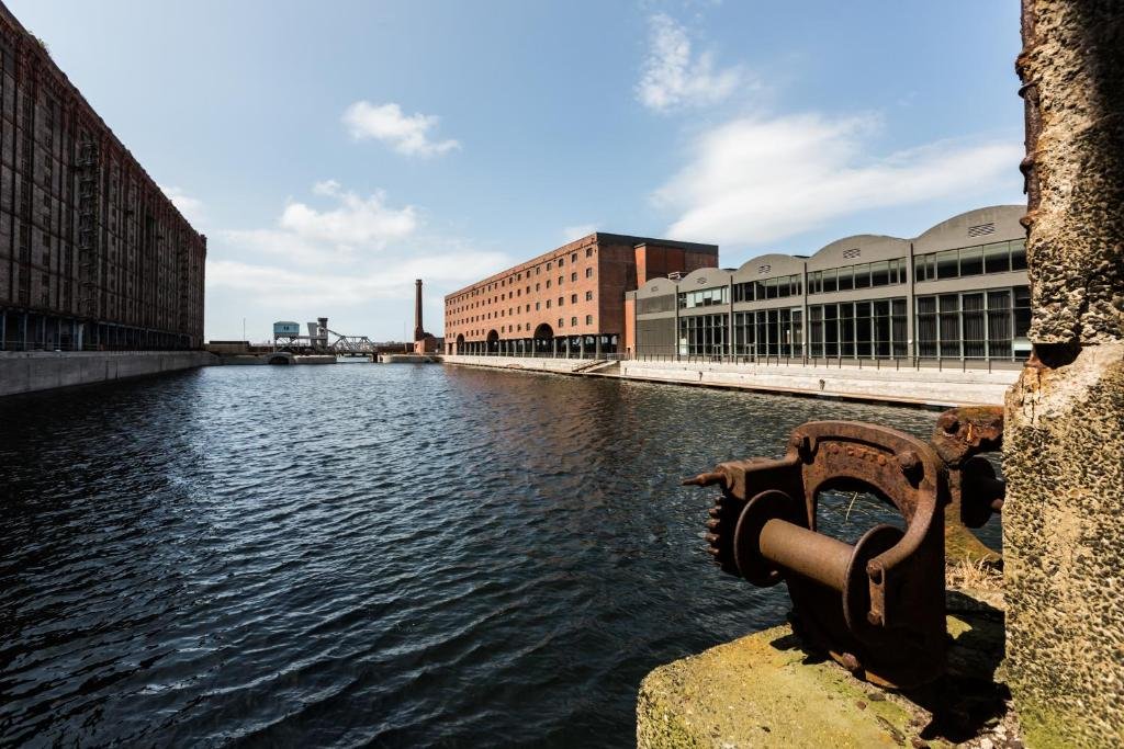 Rio com prédios em volta, sendo um o Titanic Hotel Liverpool