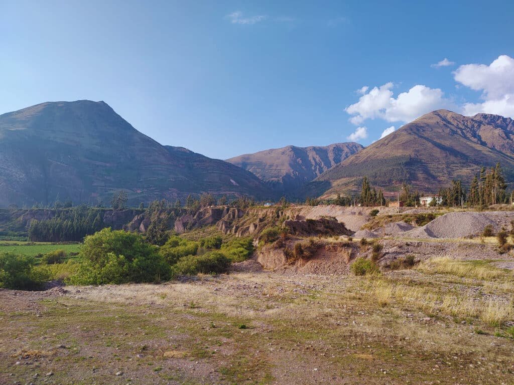 vale de Urubamba mostrando as montanhas peruanas ao fundo, em contraste com o céu azul.